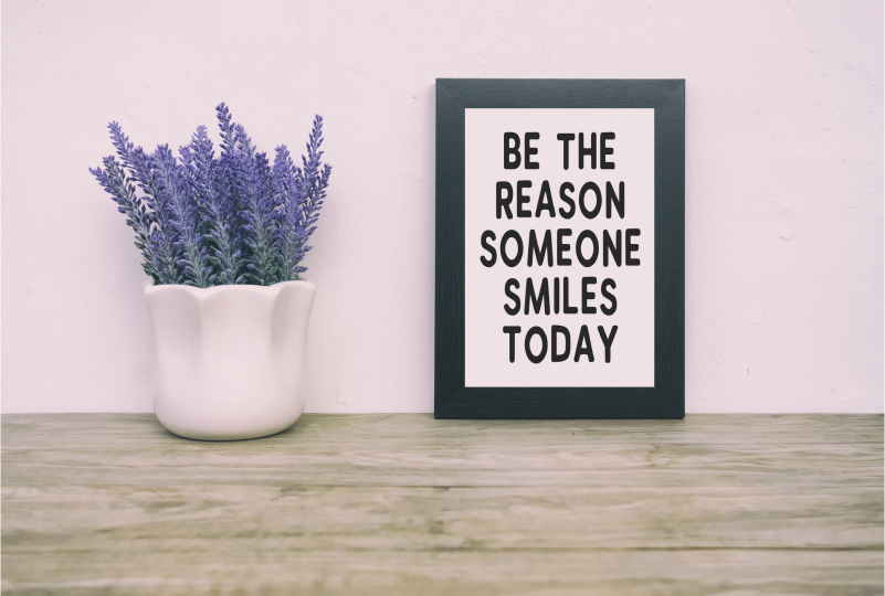 Framed quote beside lavender in a vase.